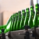 A row of green bottles on a production line