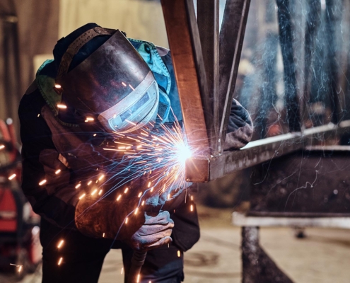 Person welding metal beams togetehr